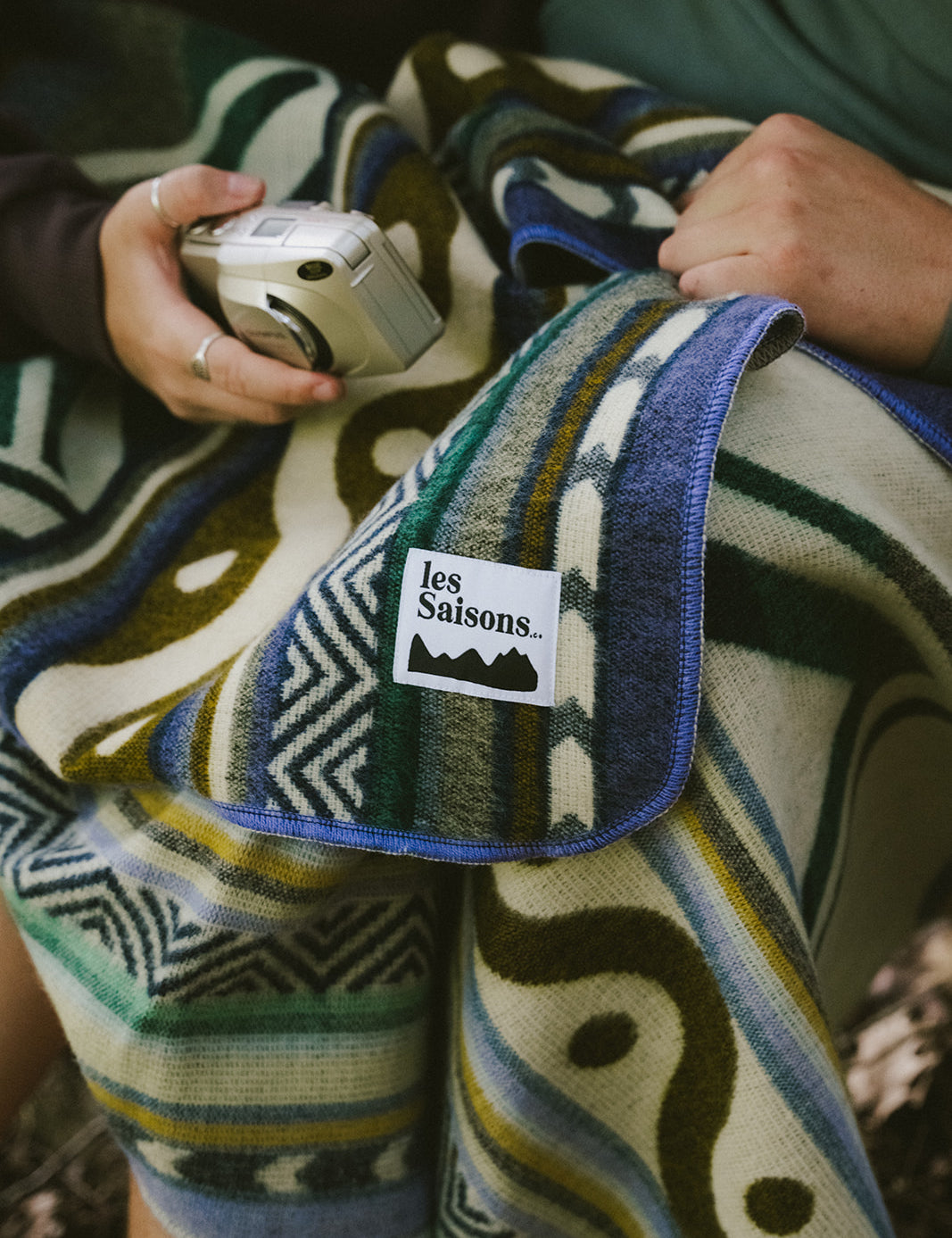 Blanket, shades of blue, yellow, grey, red, brown, blue, lightweight, mountain designs, handcrafted in Ecuador, Acrylic, durable, 70" x 48", soft, camping, van life, outdoors, lifestyle, Les Saisons, Marine Poiraton 